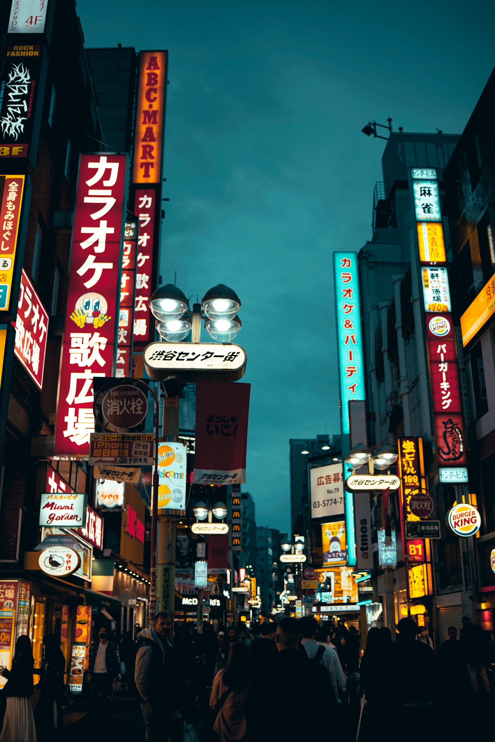 Bustling Shibuya street scene in Tokyo's nightlife with neon signs and pedestrians.